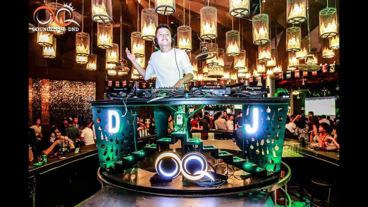 OQ 클럽 중앙 DJ 부스 — 원형 조명 구조물과 둘러앉은 손님들
